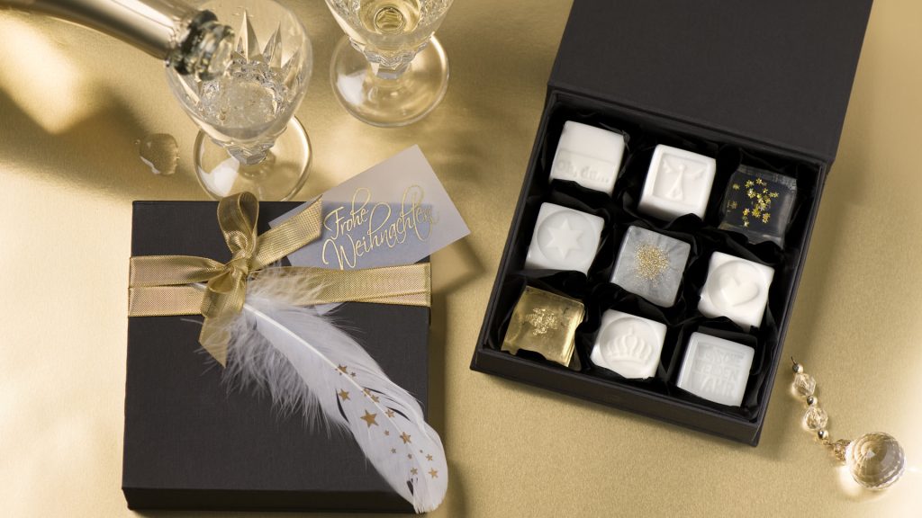 Ideen mit Seife für Weihnachten: Schmucke Stücke | Seifen als kleine Pralinen in Weiß und Transparent mit goldenen Sternen, Blattmetall in Gold und Flitter verziert