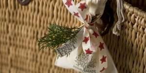 Ideen mit Badekugeln für Weihnachten: Frohes Fest | Eine Badekugel verpackt im Stoffbeutel mit Aufdruck Homemade. Natur mit Tannenweig und roten Sternen